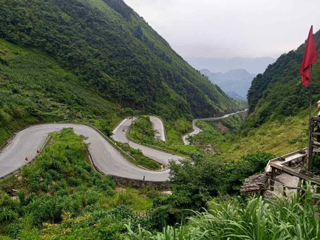 Carretera de montaña con curvas entre laderas verdes en Vietnam