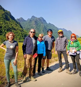 Grupo de viajeros caminando juntos por una carretera rodeada de montañas en el norte de Vietnam