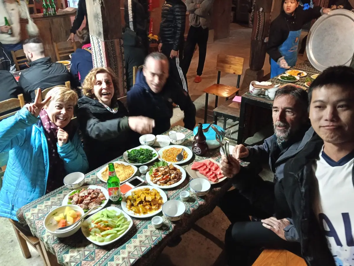 Grupo de viajeros compartiendo una mesa llena de platos locales durante una cena en Vietnam